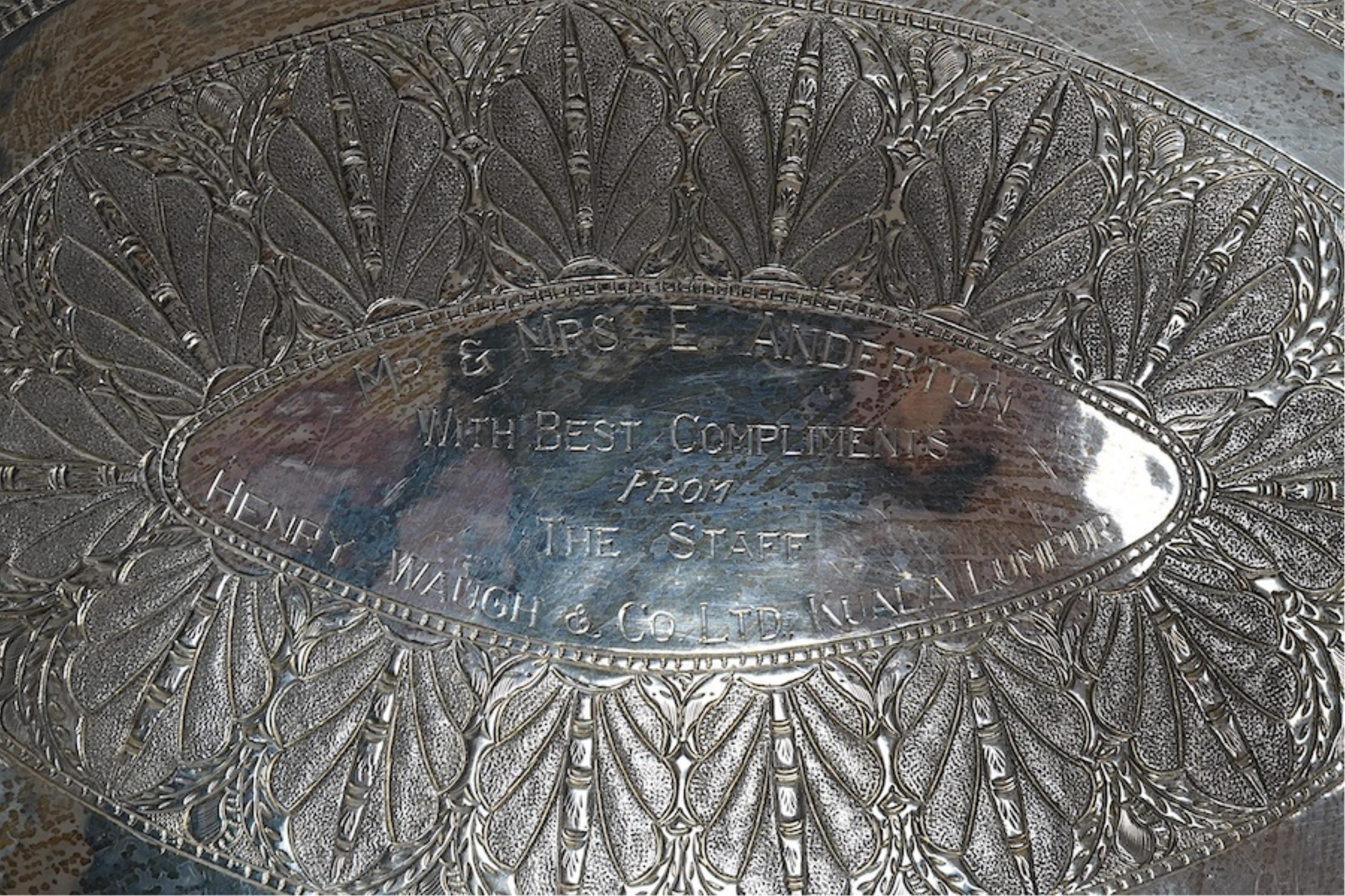 An Indonesian white metal oval dish, embossed and chased with the coats of arms of regions of Indonesia and Singapore, with a central leaf border and inscription, 38.5cm wide, 648g. Condition - good